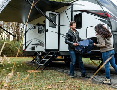 Couple setting up a caravan at a camp site