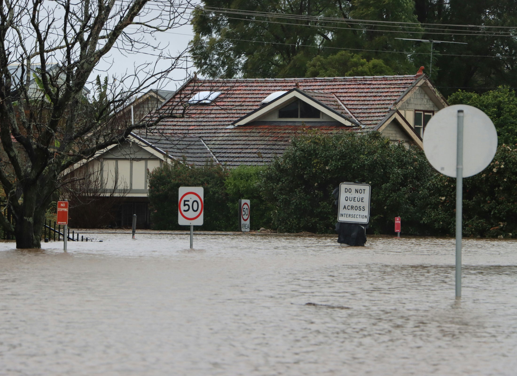 Street signs and houses inundated by floodwater