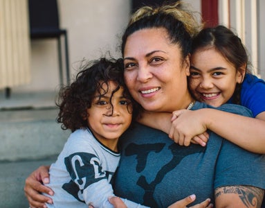 A woman in a loving embrace with children