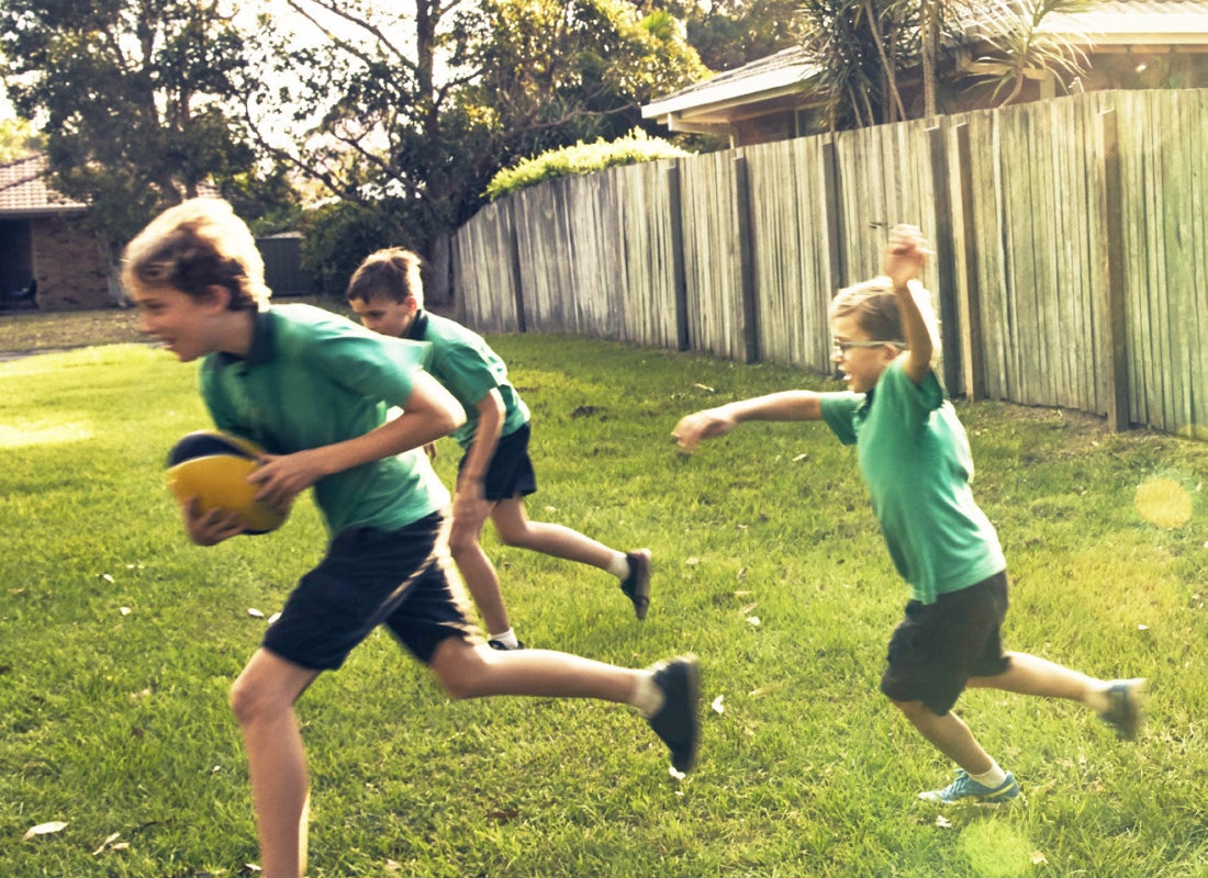 Australian children playing footy in the backyard