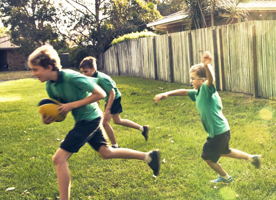 Australian children playing footy in the backyard