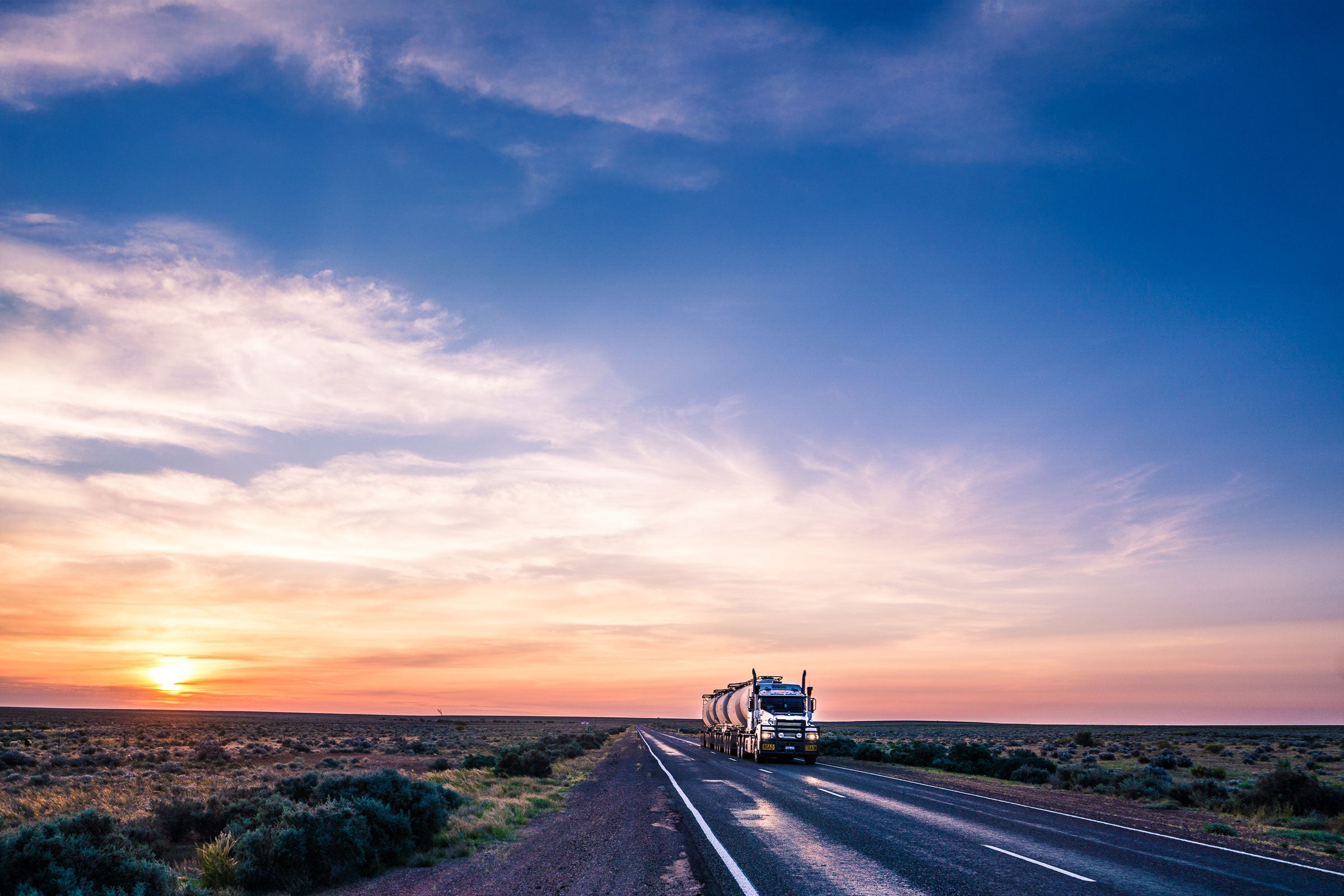 Large truck travelling on a long and open road