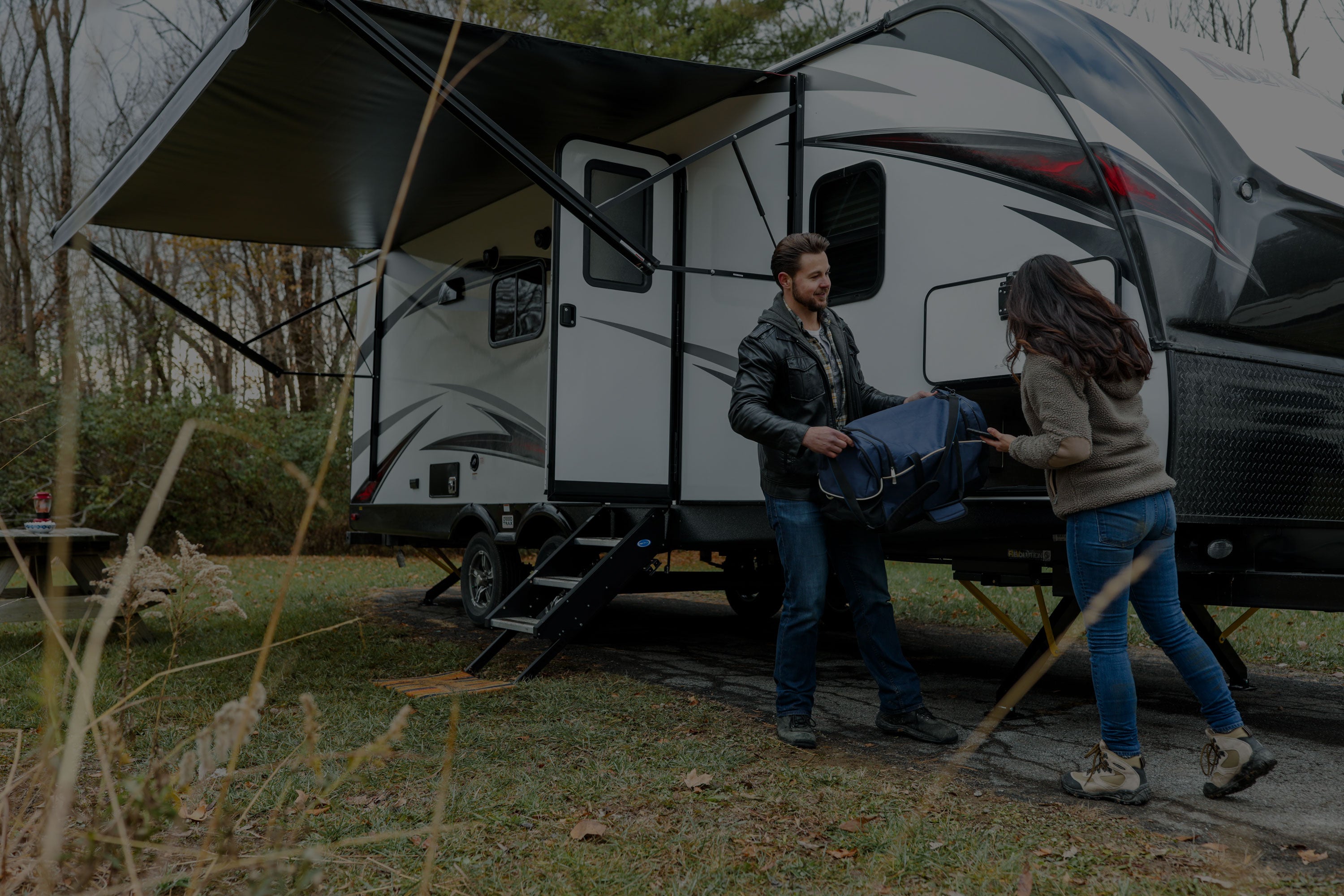 Couple setting up a caravan at a camp site