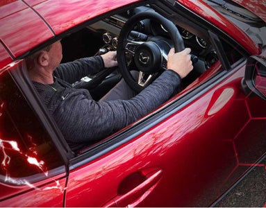 Driver sitting in a red sports car