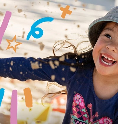 A happy Goodstart child playing in a sandpit